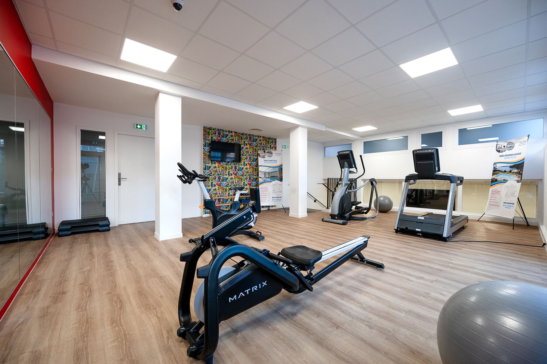 A gym with cardio machines, a rowing machine, and a stationary bike.