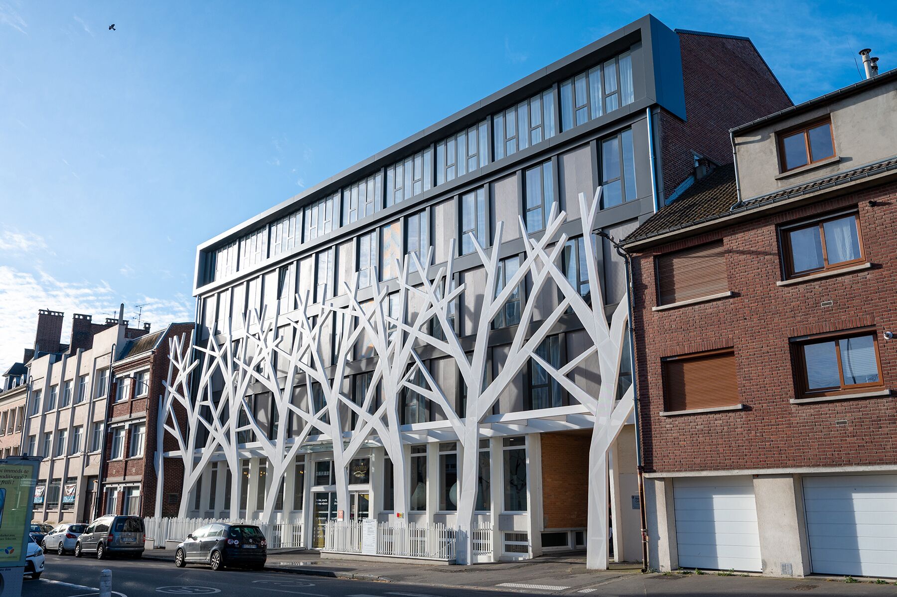 Ein modernes Gebäude mit einem einzigartigen, weißen Bauweise-Design, großen Fenstern und einer Ziegelaußenwand.