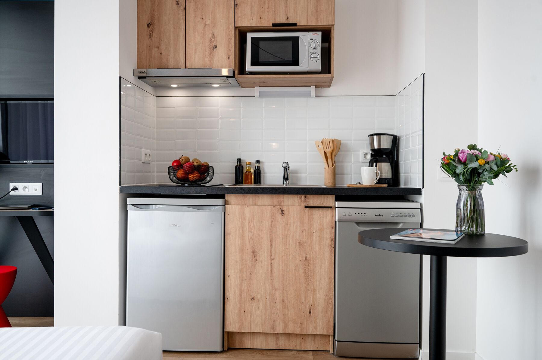 Una cocina moderna con microondas, lavavajillas y cafetera integrados.