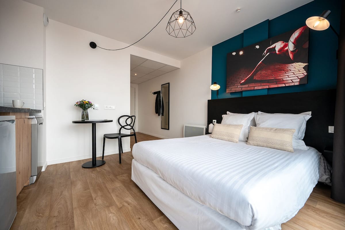 Ett modernt hotellrum med en stor säng, ett skrivbord och en matplats.