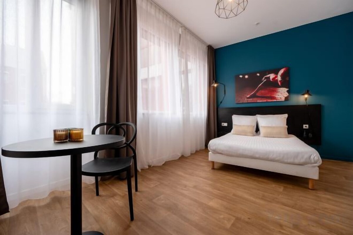 A room with a bed, a round table, and a chair.