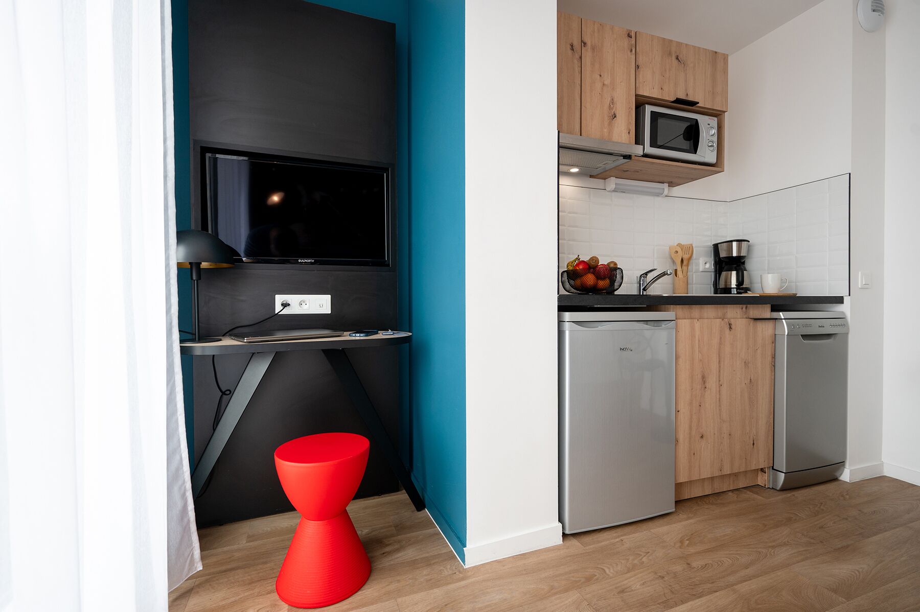 Una cocina compacta equipada con microondas, cafetera y lavavajillas.