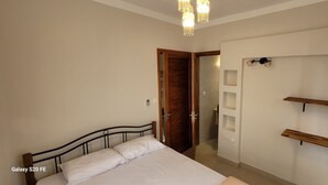 A bedroom with a bed, a wardrobe, and a shelf unit. - Brand new Private self catering Apartment situated in Flic en Flac (Flic en Flac)