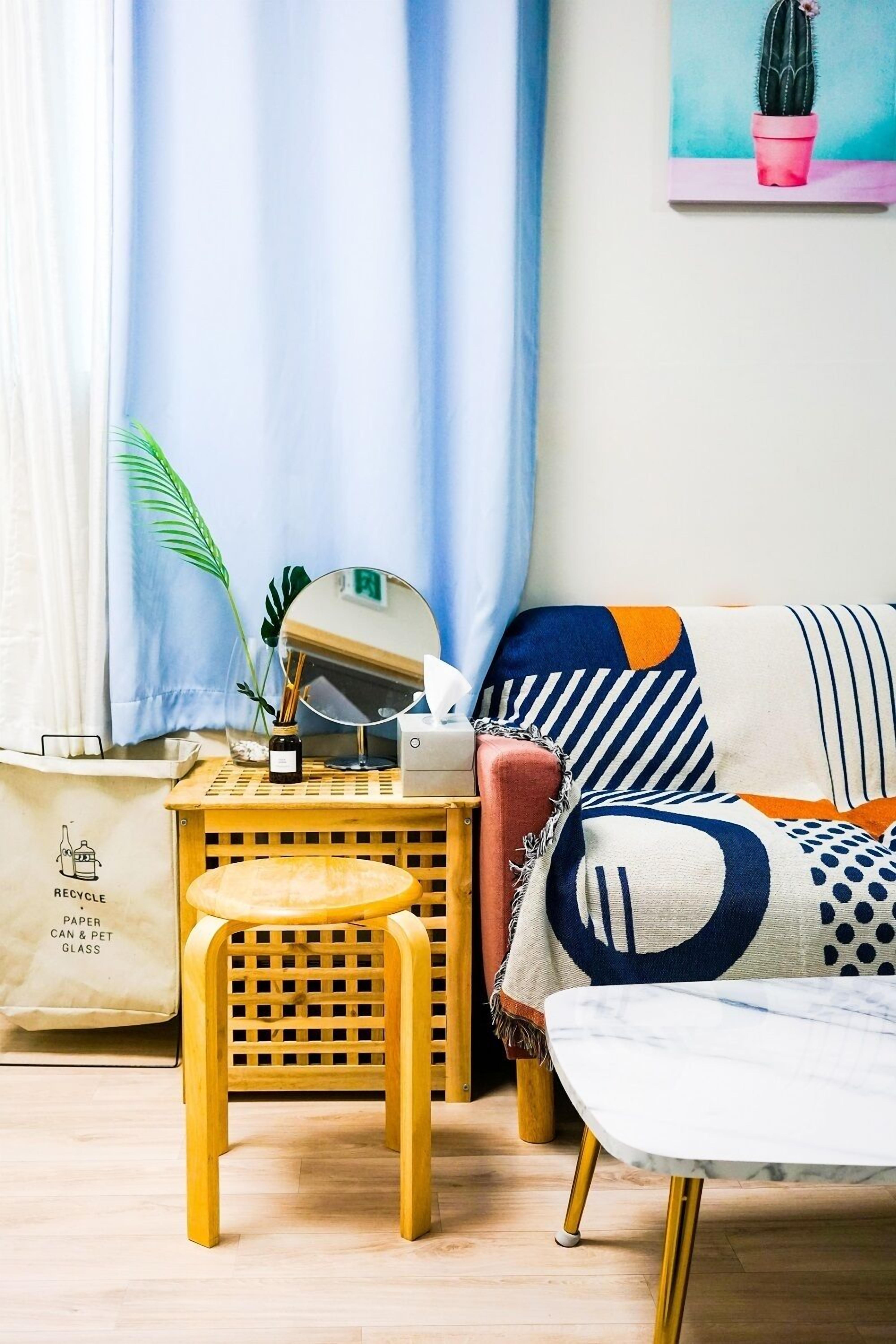 A cozy living room with a wooden coffee table, a cushioned bench, and a sofa with patterned cushions.
