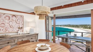 A dining area with a view of a beach and ocean. - Vista del Mare - Indulge yourself in the lap of luxury with endless ocean views (Mollymook Beach)