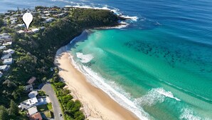An aerial view of a coastal area with a beach, houses, and a marker indicating a location. - Vista del Mare - Indulge yourself in the lap of luxury with endless ocean views (Mollymook Beach)