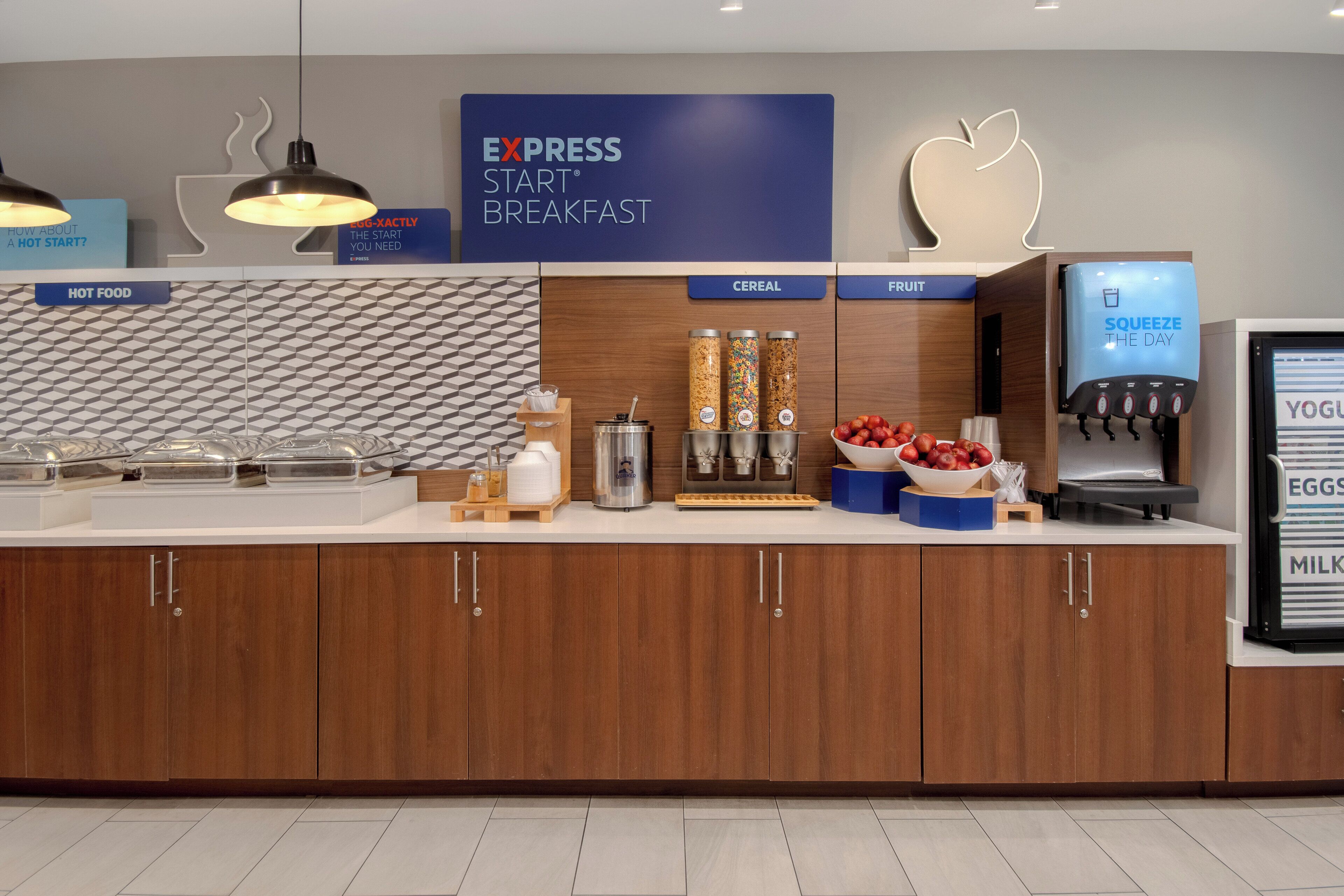 Un espace pour le petit-déjeuner à l’hôtel, avec des sections clairement indiquées pour les plats chauds, les céréales et les fruits.