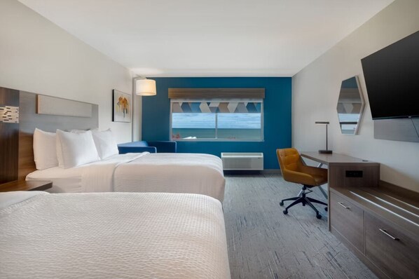 A hotel room with two beds, a desk, a chair, a TV, and a window with a view of the sea. - Holiday Inn Express and Suites Oscoda by IHG (Oscoda)