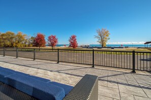 A paved walkway with a metal railing, benches, and a view of the sea and a bridge. - Holiday Inn Express and Suites Oscoda by IHG (Oscoda)