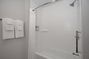 A modern bathroom with a glass-enclosed shower, a white bathtub, and a towel rack with two towels. - Holiday Inn Express and Suites Oscoda by IHG (Oscoda)