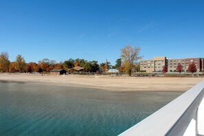 A waterfront hotel with a sandy beach, a covered pavilion, and a multi-story building with a sign for the Holiday Inn Express. - Holiday Inn Express and Suites Oscoda by IHG (Oscoda)