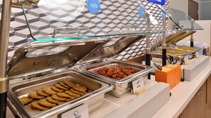 A buffet with labeled trays of turkey sausage and cookies. - Holiday Inn Express and Suites Oscoda by IHG (Oscoda)
