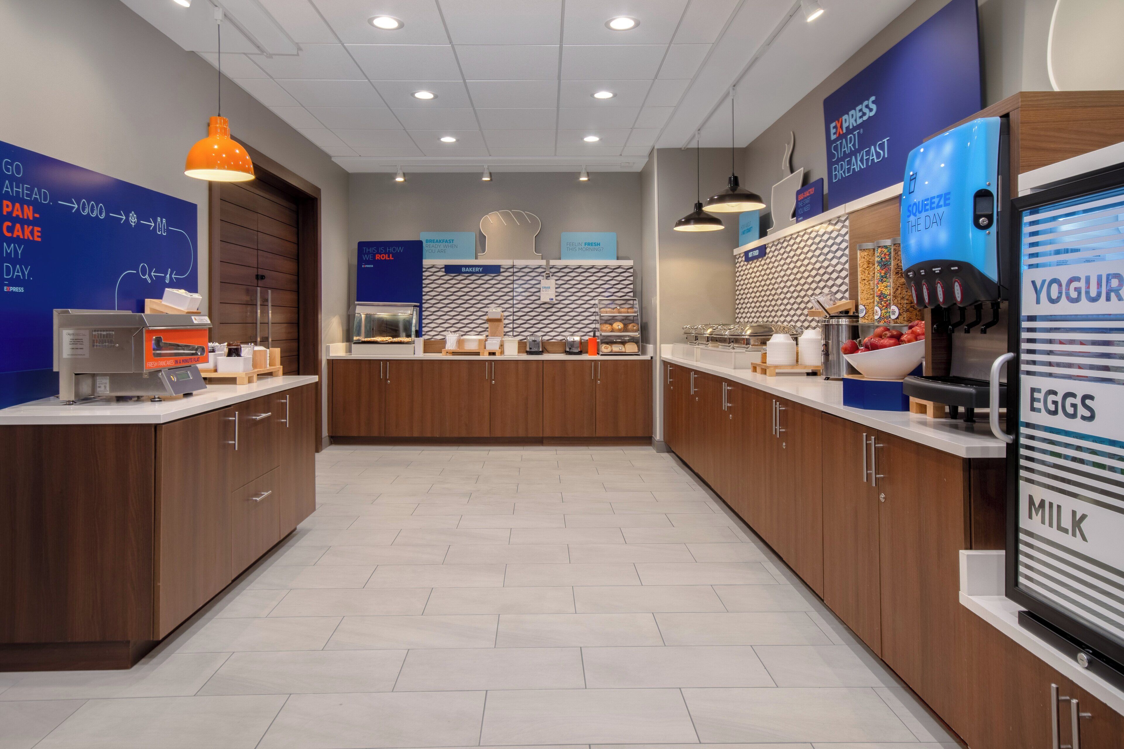 Un moderno espacio para el desayuno con mostrador de panadería, estación de yogur y huevos, y máquina de café.