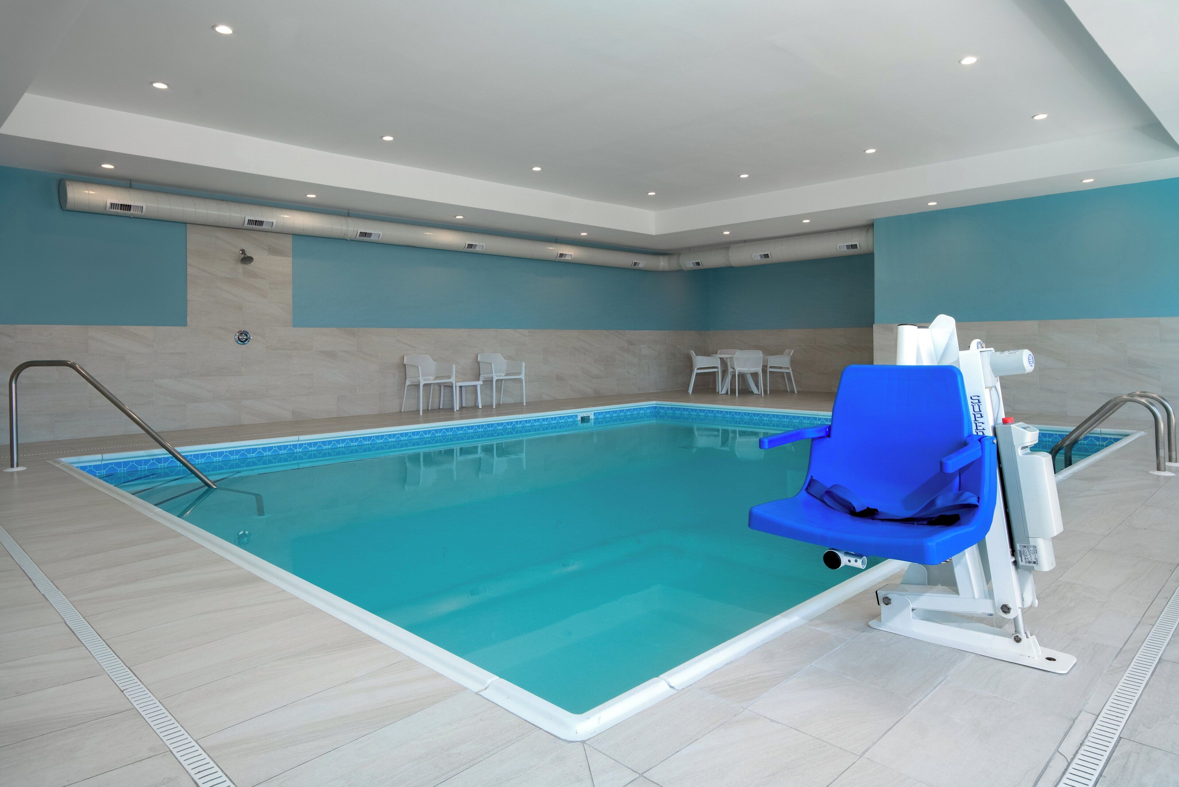 A swimming pool with a blue chair and a water slide.