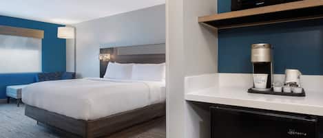 Une chambre d’hôtel équipée d’un lit, d’un bureau avec une machine à café et d’un four à micro-ondes.