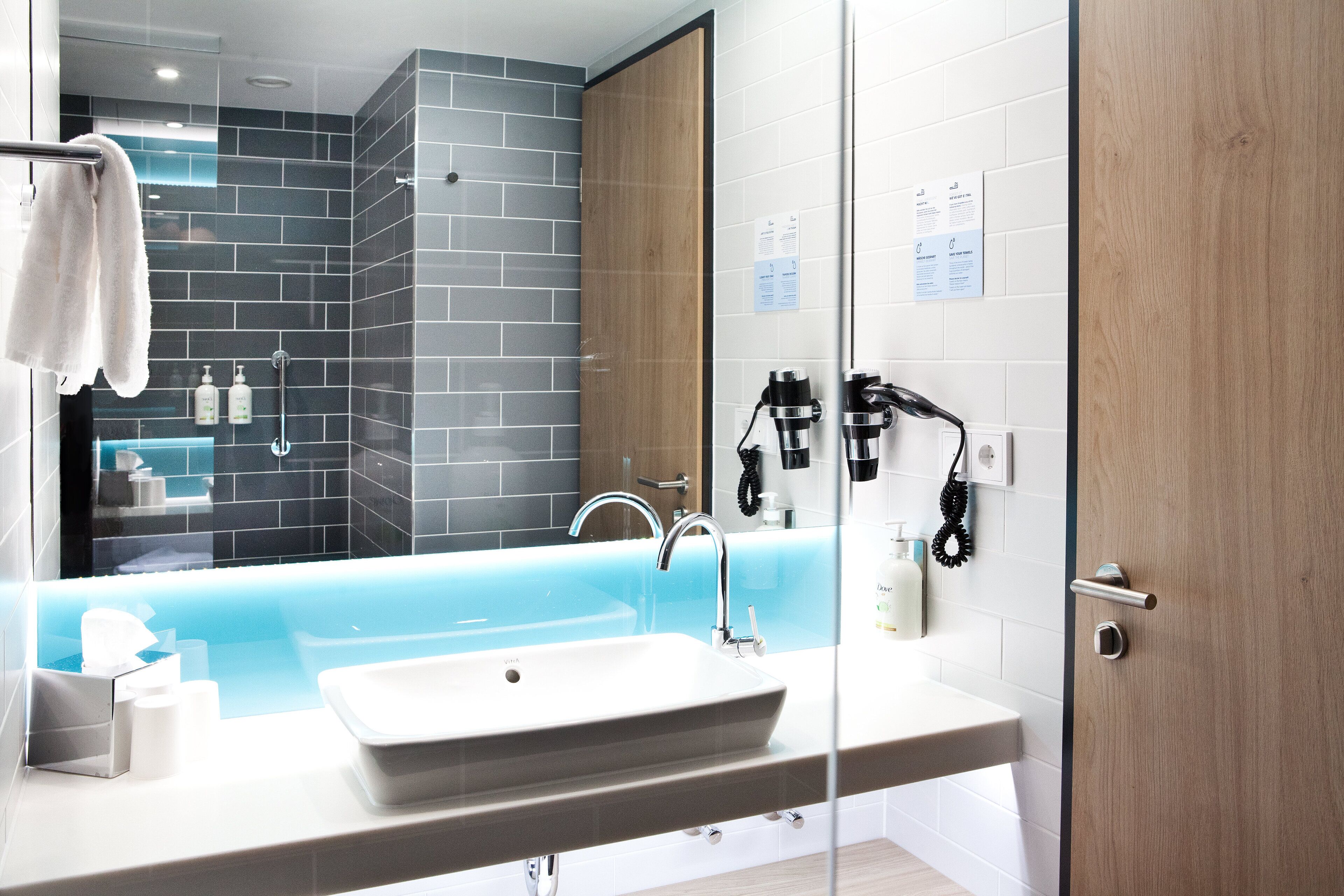 A modern bathroom with a large bathtub, a sink, and a mirror.