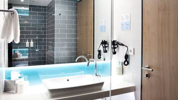 A modern bathroom with a large bathtub, a sink, and a mirror.