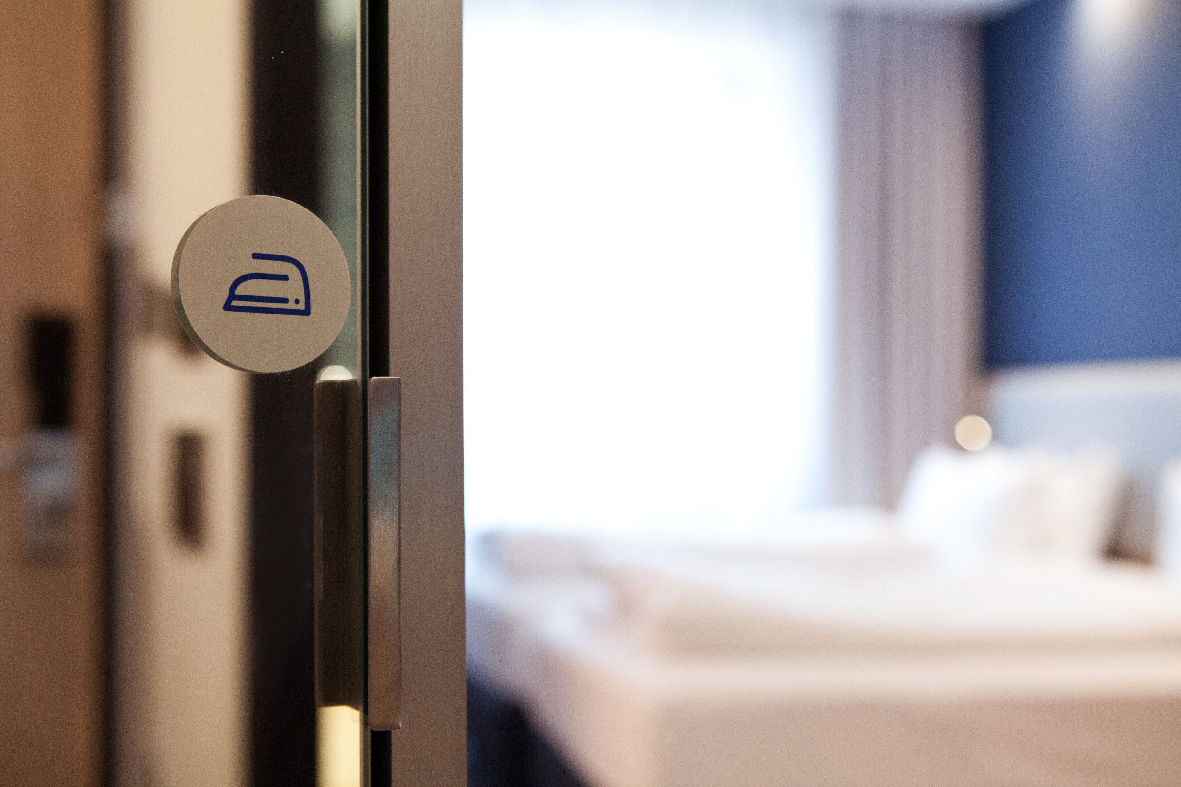 A hotel room door with a bed and a sign indicating a room type.