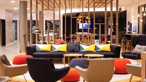 A modern lounge area with a sofa set, armchairs, and a coffee station. - Holiday Inn Express Bochum by IHG (Bochum)