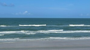 A beach with waves and a clear sky. - Stunning direct ocean front 2 bedroom unit! Fully equipped and all remodeled! (New Smyrna Beach)