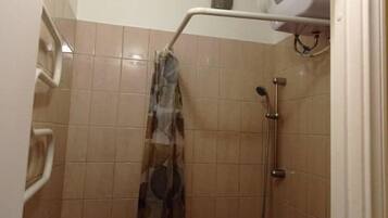 Een douche, handdoeken, zeep, toiletpapier