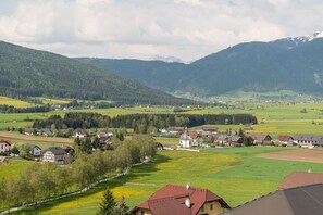 Un poble rural amb cases, una església i muntanyes al fons.