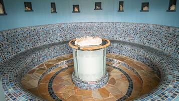 Surrounded by a ring of stone tiles, this pool area features a central column and framed pictures on the walls.