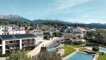 Zona residencial con piscina, edificios modernos y montañas al fondo.