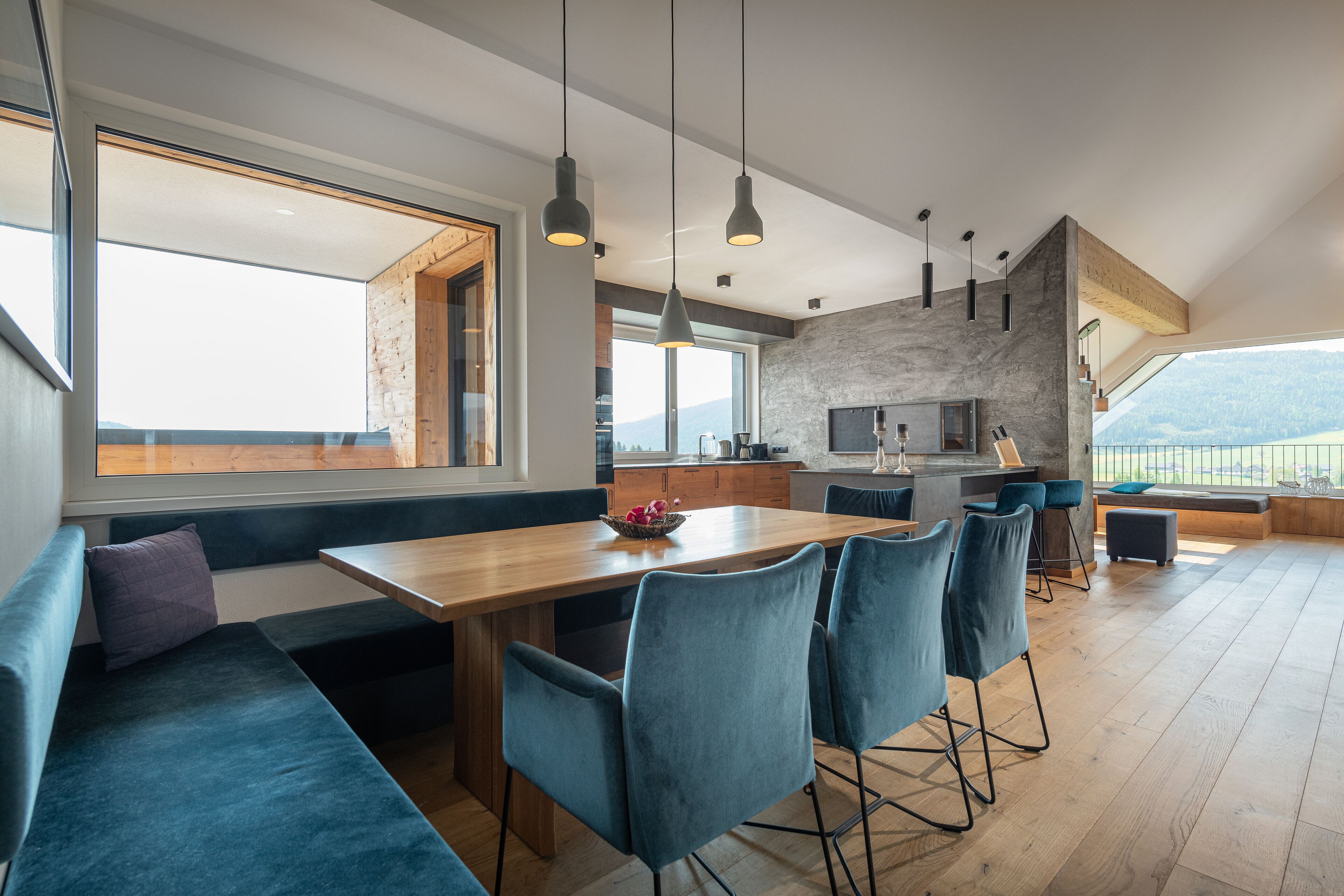 A modern kitchen with a stone backsplash, wooden countertops, and a large window overlooking a scenic view.