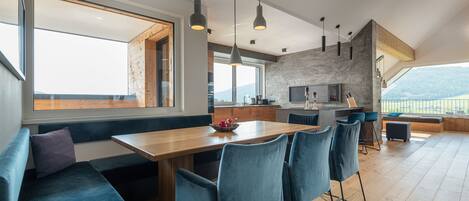 A modern kitchen with a stone backsplash, wooden countertops, and a large window overlooking a scenic view.