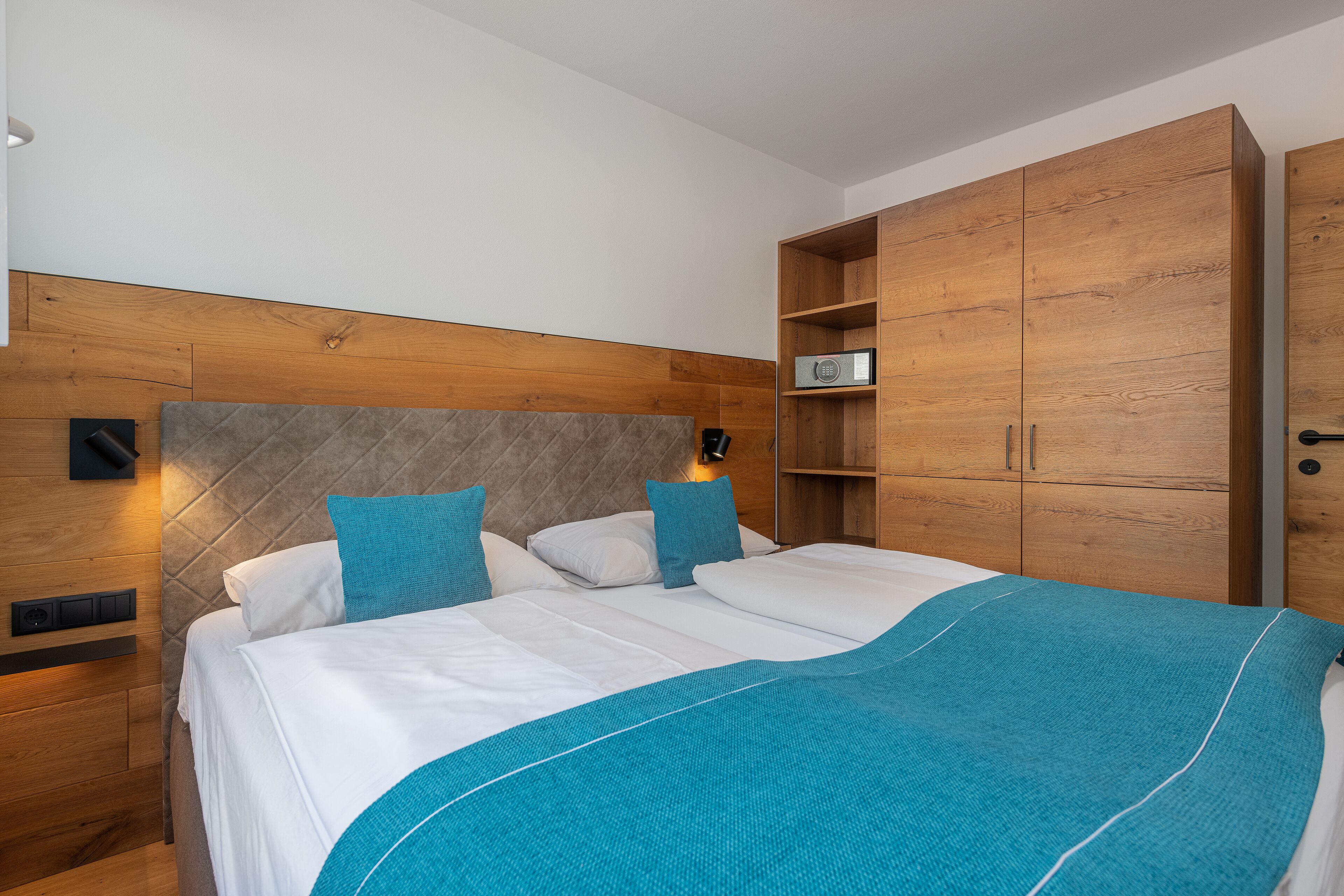 Un dormitorio moderno con una cama grande, cabecera de madera y estanterías empotradas.