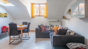 A modern living room with a dining area, a sofa, a red guitar, and a window with yellow curtains. - BnButler - Asiago 41 (Milan)