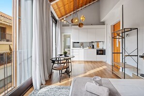 Un appartement moderne doté d’un coin repas, d’une cuisine et d’un balcon avec vue.