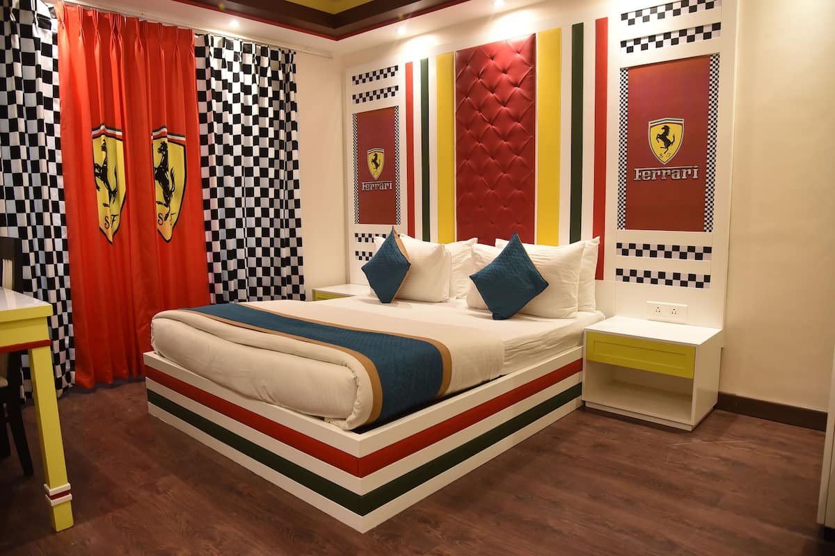 A bedroom with a bed, pillows, a nightstand, and a desk.