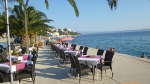 En restaurant ved havet med udendørs siddepladser og udsigt over havet, samt en datoangivelse fra 2/JUL/2015.