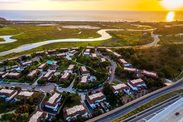An aerial view of a residential area with houses, roads, and a body of water.