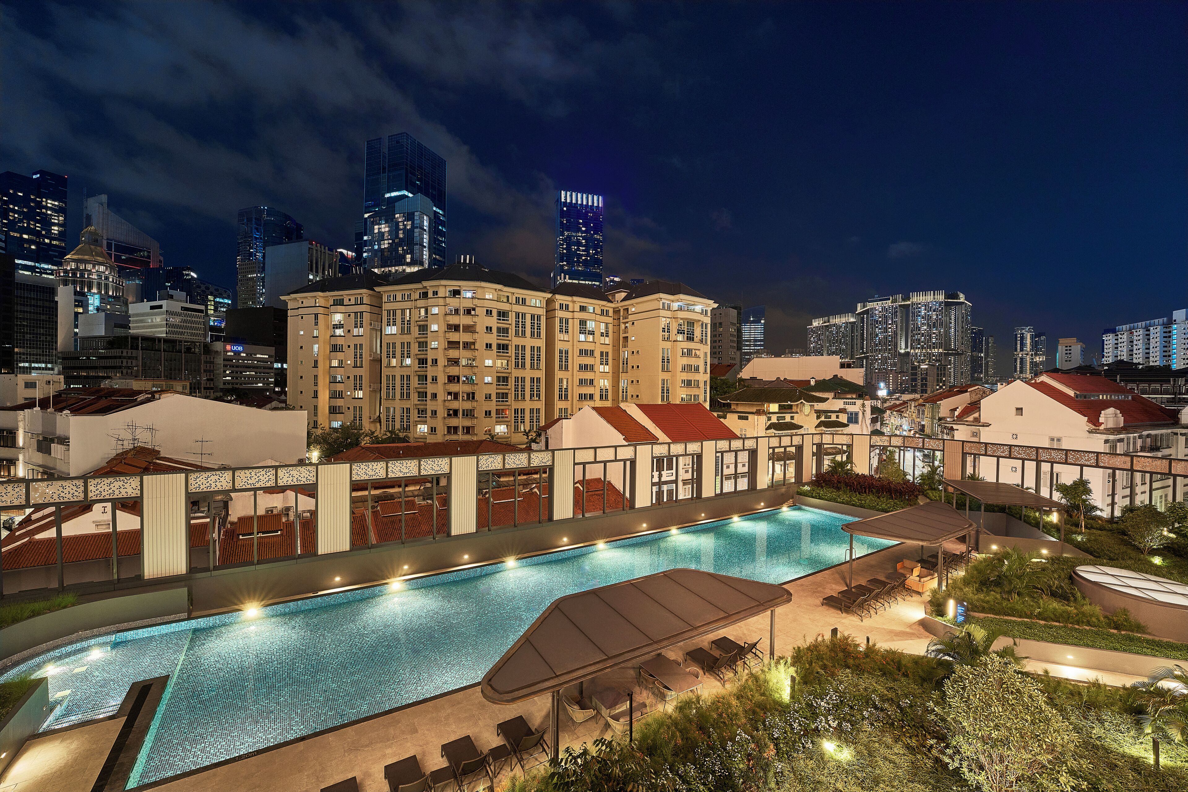 Una piscina al aire libre, sillones reclinables de piscina