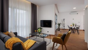 Een moderne woonkamer met een bank, salontafel en een flatscreen televisie.