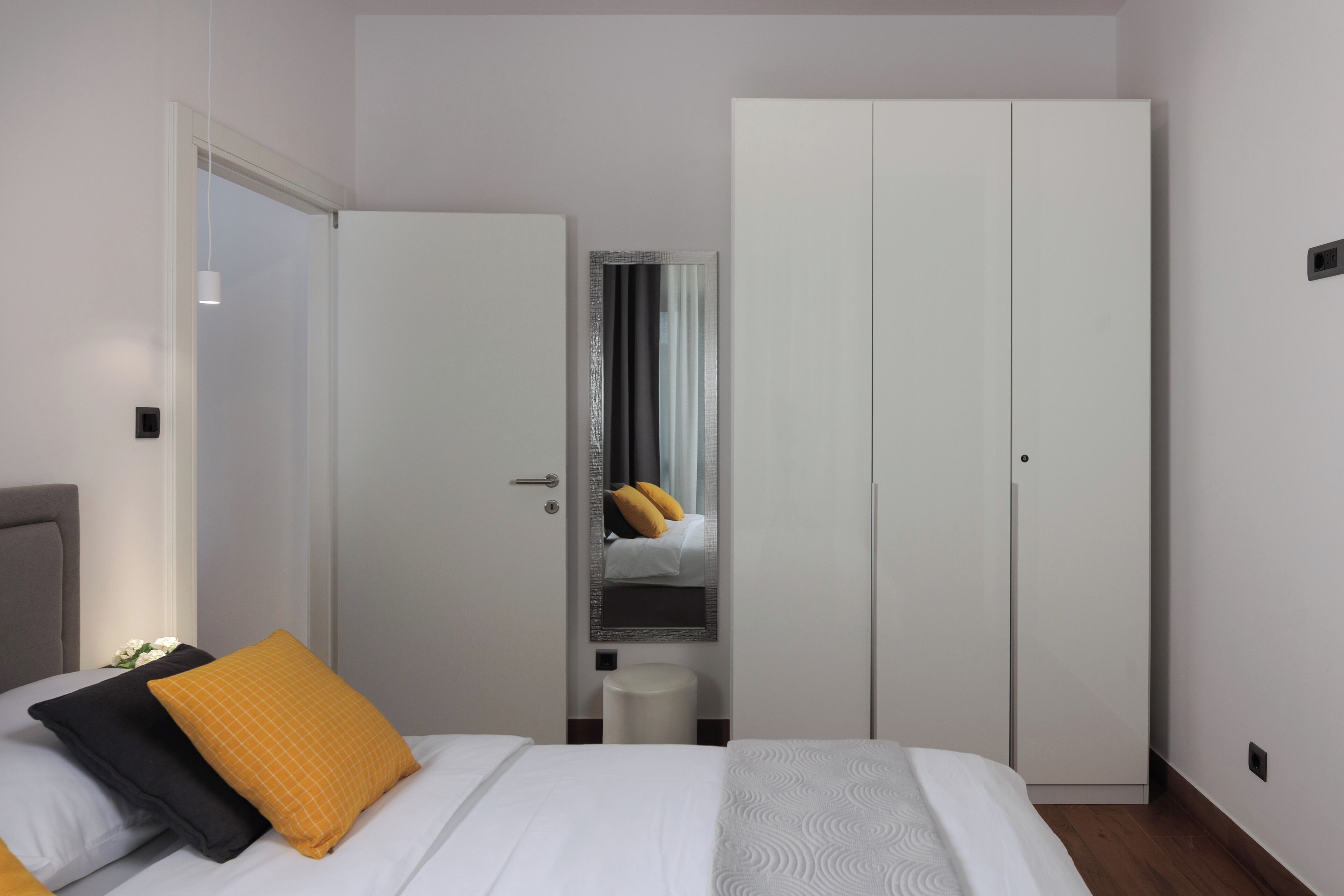 Une chambre d’hôtel avec un lit, une armoire et un miroir.
