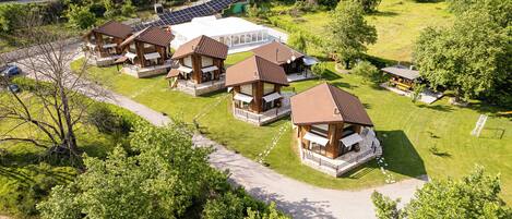 Una cabaña con varias cabañas, un edificio central y paneles solares.