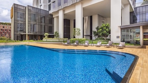 Un hotel moderno con piscina, zona de estar al aire libre y jardín ajardinado.