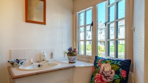 A bathroom with a sink, mirror, and window. - Red Robin Cottage -  Garden, Parking and Walk to the Lake (Ambleside)
