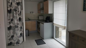 A compact kitchen with a microwave, coffee maker, and cabinets.