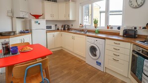 Eine kleine Küche mit Waschmaschine, Spüle und Toaster.