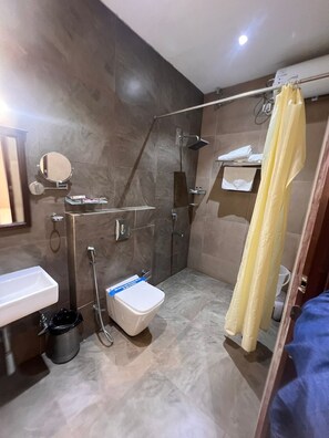 A modern bathroom with a shower, toilet, sink, and a mirror.