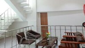 A modern interior with a staircase, seating area, and a view of the outdoors.