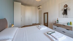 Ein Schlafzimmer mit einem Bett, einem Schminktisch, einem Spiegel und einem Bild an der Wand.