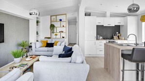 Un appartamento moderno con soggiorno, cucina e zona pranzo.