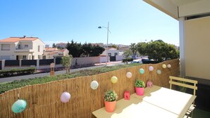 A balcony with a table and chairs, potted plants, and decorative paper lanterns. - Studio for 4 with swimming pool and parking (Canet-en-Roussillon)