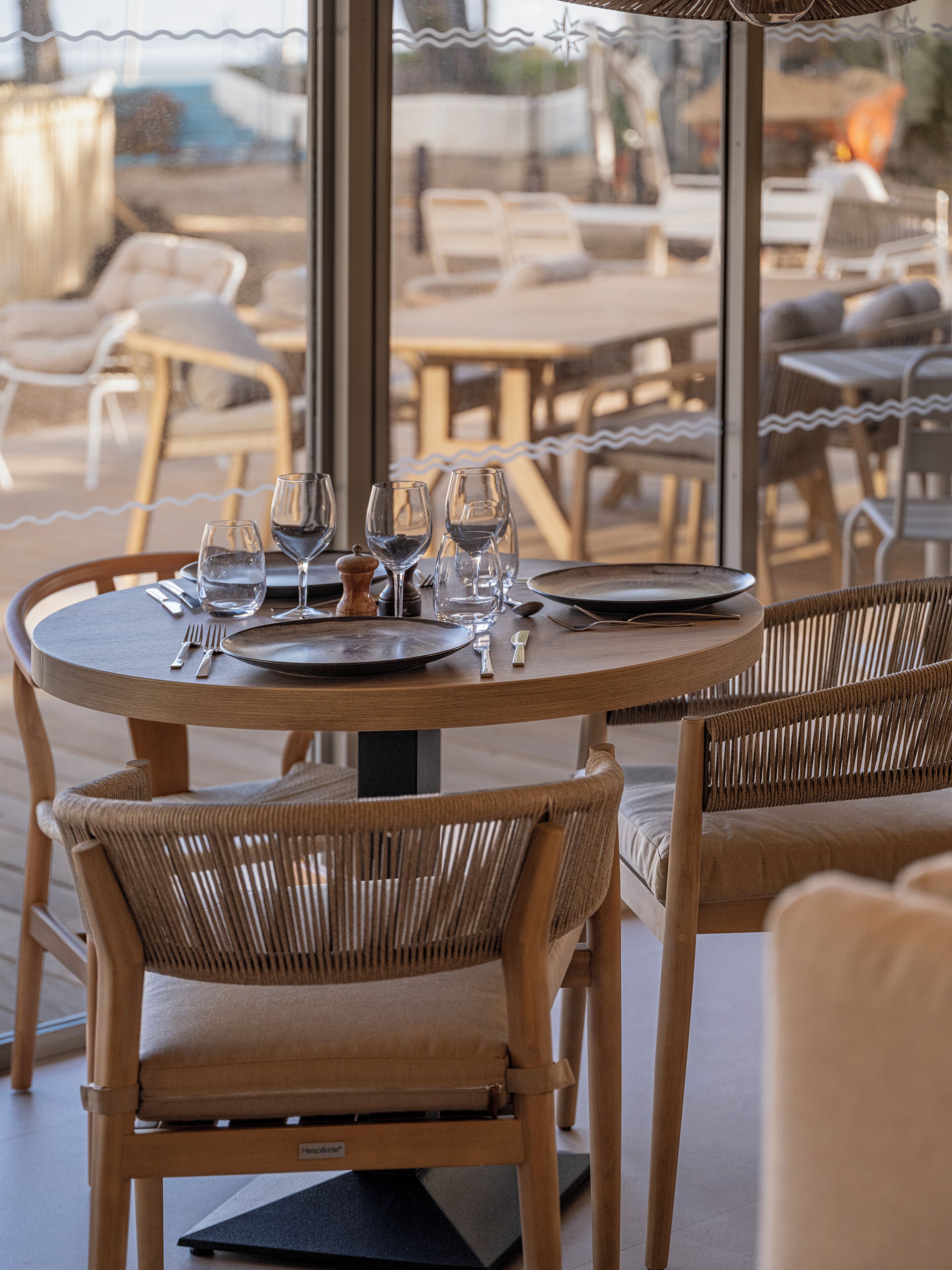 A round dining table with chairs, set for a meal.